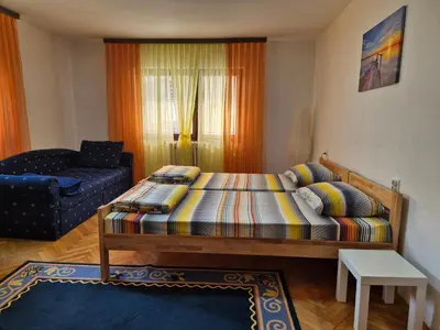 a small bedroom with a bed and a chair at City Center Stay in Visoko