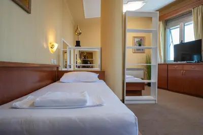 a bedroom with a bed with white sheets and a television at Rio apartments in Banja Luka