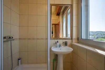 a bathroom with a sink and a shower with a window at Rio apartments in Banja Luka