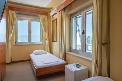 a small room with a bed and two windows at Rio apartments in Banja Luka