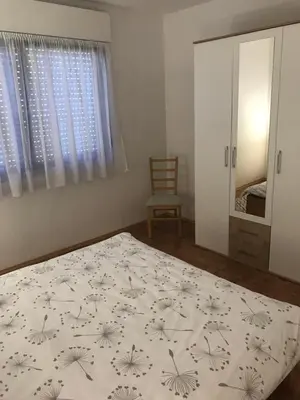 a bedroom with a bed and a chair and a mirror at Apartmani Golubina - Trn, Laktasi, BANJA LUKA in Grabljani