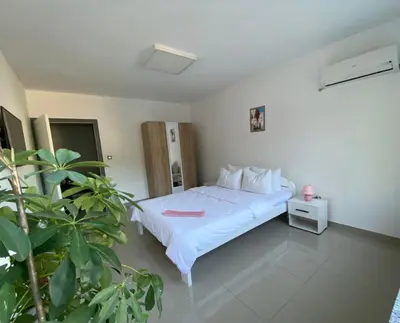 a bedroom with a white bed and a plant at Gatto in Jajce