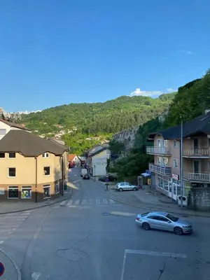 an empty street in a small town with houses and a car at Gatto in Jajce