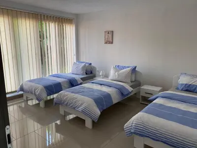 three beds in a room with blue and white sheets at Gatto in Jajce