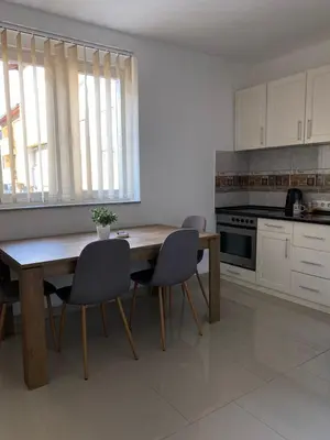 a kitchen with a wooden table and two chairs at Gatto in Jajce