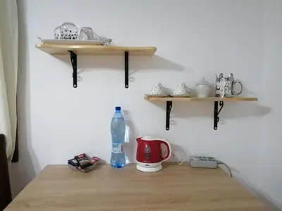 a wooden shelf with a bottle of water on a table at Sobe RoomsBella in Ripač
