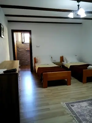 a room with two beds and a table in it at Sobe RoomsBella in Ripač