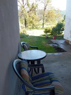 a table and a chair and a table and a table and chairs at Sobe RoomsBella in Ripač