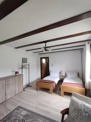 a bedroom with two beds and a couch in it at Sobe RoomsBella in Ripač