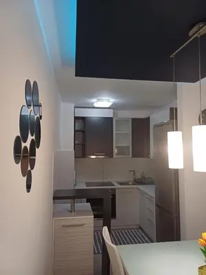 a kitchen with a table and a black counter top at Apartman 
