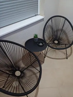two chairs and a table next to a window at Apartman 