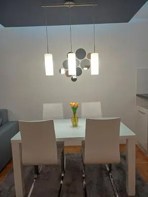 a dining room with a white table and chairs at Apartman 