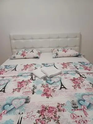 a bed with a hello kitty bedspread and pillows at Apartman 