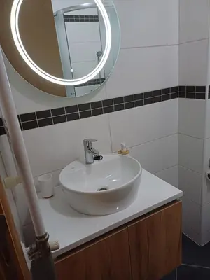 a bathroom with a white sink and a mirror at Apartman 