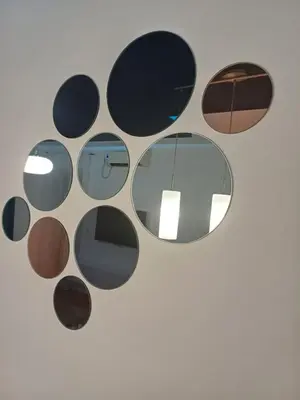 a circular mirror hanging on a wall at Apartman 
