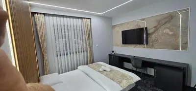 a hotel room with a bed and a flat screen tv at Luxury Room 's in Velika Kladuša