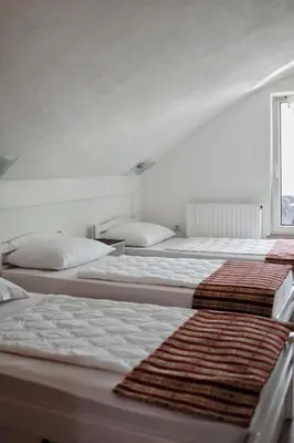 a group of three beds in a room at Holiday Home Casa Rondo in Bihać