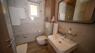 a bathroom with a sink and a toilet and a mirror at SM Exclusive Apartments in Visoko