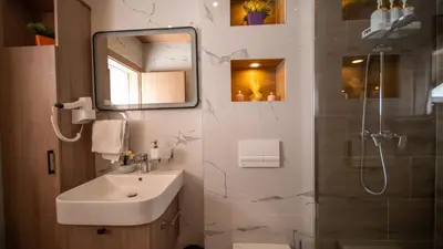 a bathroom with a sink and a mirror and a shower at SM Exclusive Apartments in Visoko