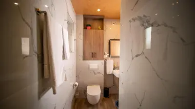 a white bathroom with a toilet and a sink at SM Exclusive Apartments in Visoko