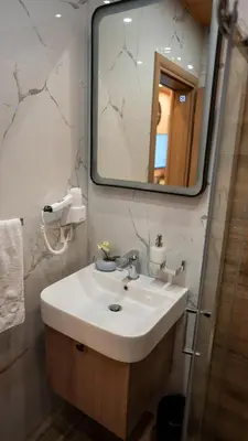 a bathroom with a white sink and a mirror at SM Exclusive Apartments in Visoko