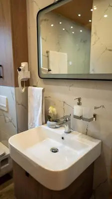 a bathroom with a white sink and a mirror at SM Exclusive Apartments in Visoko