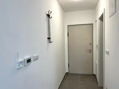 a hallway with white walls and a door with a tv at Elegance Self check-in Free Parking in Tuzla