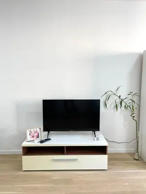 a tv on a white stand in a living room at Elegance Self check-in Free Parking in Tuzla