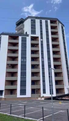 a large white apartment building with a parking lot at Elegance Self check-in Free Parking in Tuzla