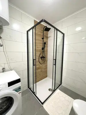 a shower in a bathroom with a washing machine at Elegance Self check-in Free Parking in Tuzla
