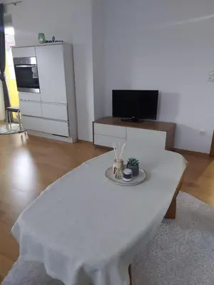a white table in a living room with a kitchen at Good Vibes in Bihać