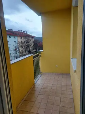 an empty balcony with a yellow wall and a window at Good Vibes in Bihać