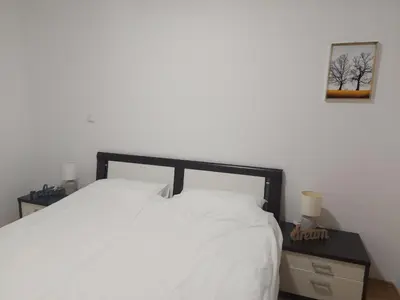 a bedroom with a white bed with a black frame at Good Vibes in Bihać