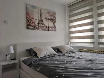 a bedroom with a bed and a picture of the eiffel tower at MLK Diamond Apartments in Starčevica