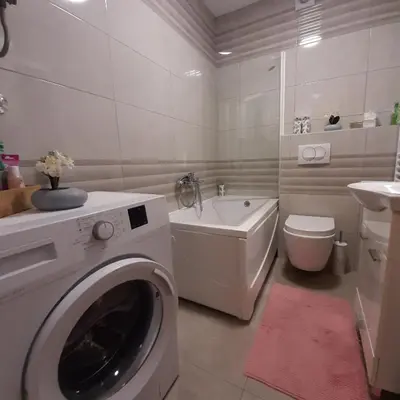 a bathroom with a washing machine and a toilet at MLK Diamond Apartments in Starčevica
