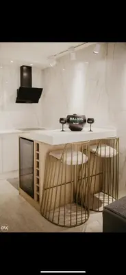 a kitchen with a counter with stools and a television at Luxury Apartment in Lukavac