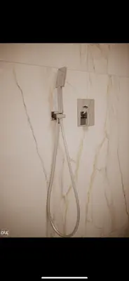 a shower in a bathroom with a marble wall at Luxury Apartment in Lukavac