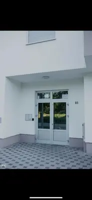 a white building with two doors and a tiled floor at Luxury Apartment in Lukavac