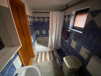 a blue tiled bathroom with a toilet and a shower at Kuća za odmor Tarik in Cazin