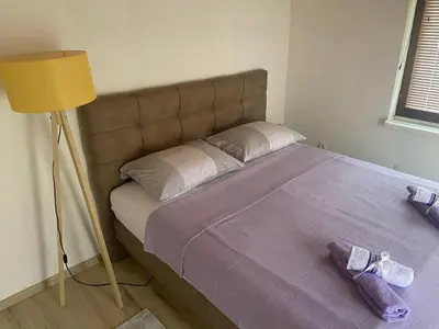 a bedroom with a bed with purple sheets and a lamp at Kuća za odmor Tarik in Cazin