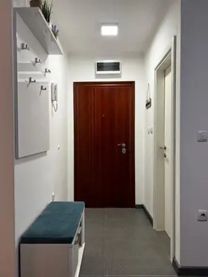 a hallway with a door and a bench in a room at Apartman 10 in Banja Luka