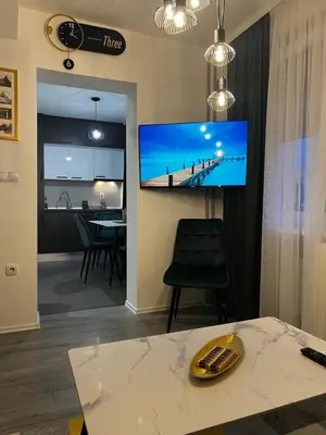 a living room with a flat screen tv on a wall at Apartman 10 in Banja Luka