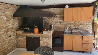 a kitchen with a stove and a brick wall at Holiday home with private pool ''Lux Banja Luka'' in Banja Luka