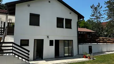 a white house with black windows and a staircase at Holiday home with private pool ''Lux Banja Luka'' in Banja Luka