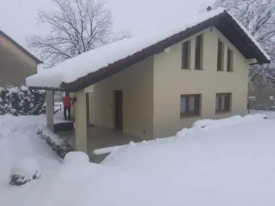 a house covered in snow with a pile of snow at Apartman Marin in Livno