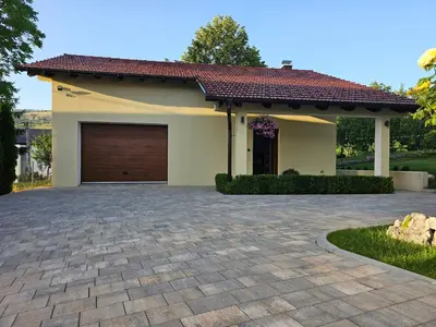 a house with a garage with a brick driveway at Apartman Marin in Livno
