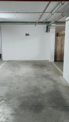 an empty parking lot with a white wall in a garage at Apartman Max in Modriča