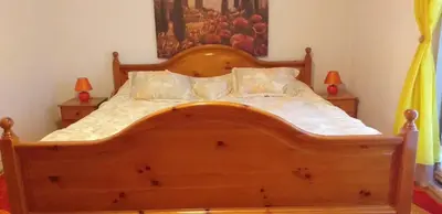 a wooden bed in a bedroom with two lamps at Vikendica M&M / Vacation home M&M in Visoko