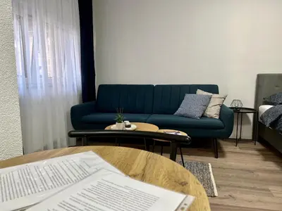 a living room with a blue couch and a table at Apartman UMA in Bihać