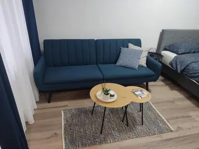 a living room with a blue couch and a table at Apartman UMA in Bihać